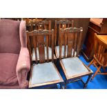 A set of four early 20th Century oak dining chairs with drop in seats