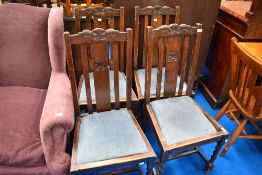 A set of four early 20th Century oak dining chairs with drop in seats