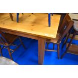 A traditional pine kitchen table having chunky square legs