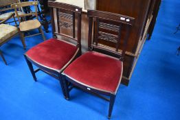 A pair of Victorian mahogany dining chairs having red dralon drop in seats
