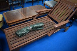 A teak steamer style garden chair with cover
