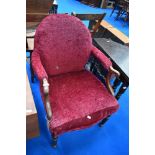 A Victorian mahogany easy chair having later burgundy upholstery and scroll arms