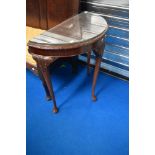 A reproduction demi lune hall table with glass top protector