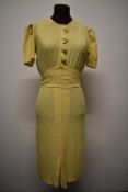 A late 1930s lemon linen day dress having scalloped detail to bodice and self covered buttons,
