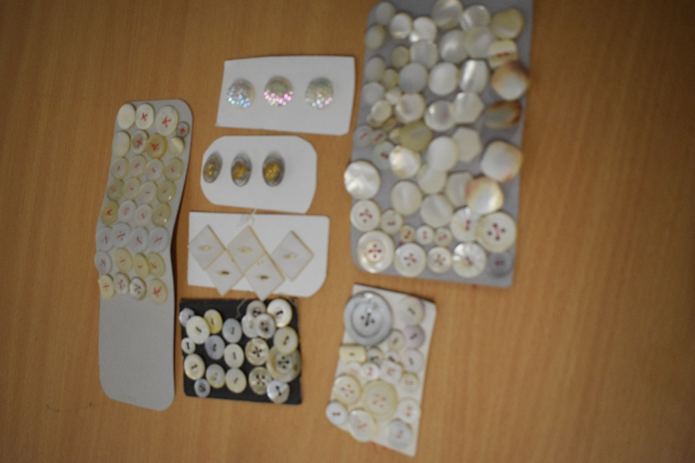 A small collection of vintage and antique buttons including mother of pearl and iridescent glass,