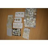 A small collection of vintage and antique buttons including mother of pearl and iridescent glass,