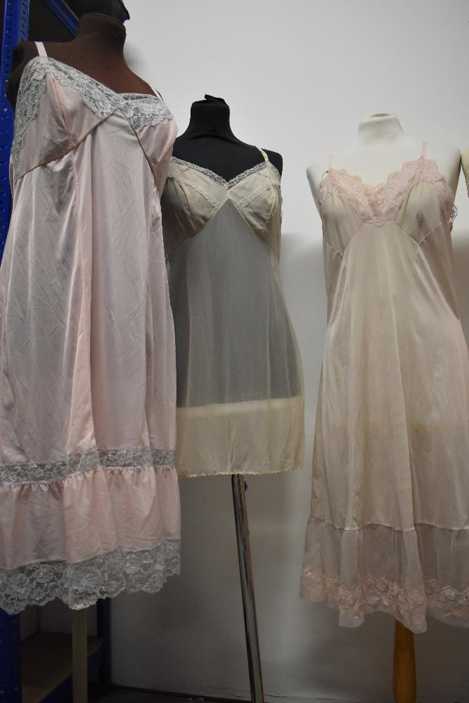 Five 1950s and 1960s sheer and semi sheer nylon slips, all having lace, medium to large sizes. - Image 11 of 12