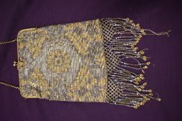 An Art Deco metallic beaded evening bag having gold tone fame and clasp fastening with blue gem