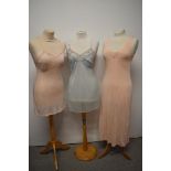 A 1950s sheer mesh slip, a pink 1930s/40s rayon slip and a 1940s nightdress with floral satin