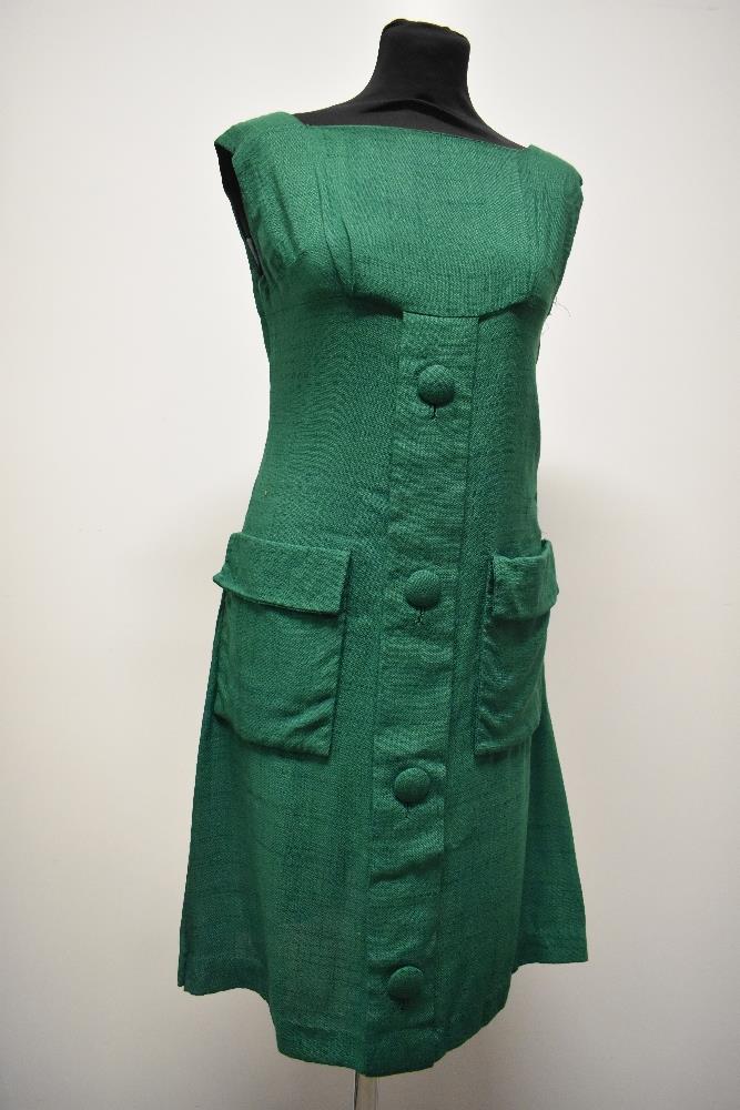 An early 1960s emerald green linen mini dress, having large self covered faux button detail to