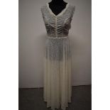 A stunning semi sheer late 1930s/ early 1940s white evening gown, having side metal zip, scalloped