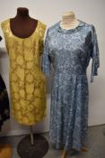Three vintage 1950s to early 1960s dresses, including oriental style black satin dress with yellow