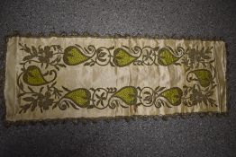 An unusual early 20th century table runner, having extensive silver tone metal coils making up