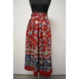 A 1940s bright red linen skirt with vibrant floral design, having high boned waist band, pleats,