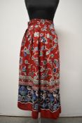 A 1940s bright red linen skirt with vibrant floral design, having high boned waist band, pleats,