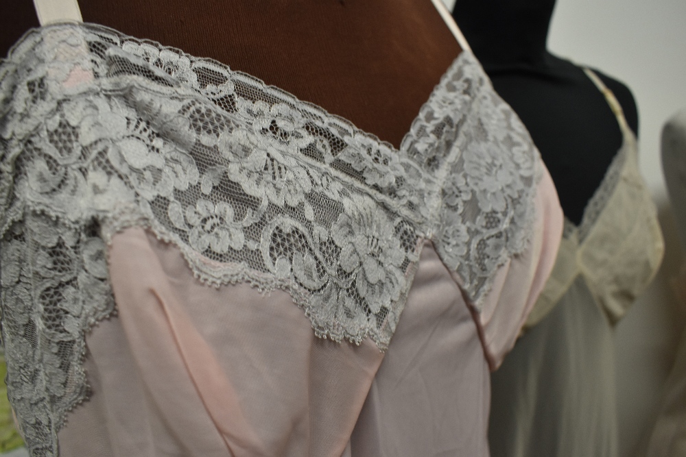 Five 1950s and 1960s sheer and semi sheer nylon slips, all having lace, medium to large sizes. - Image 6 of 12