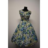 A gossamer fine silk 1950s day dress, having vibrant floral pattern and full skirt, medium to larger