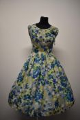 A gossamer fine silk 1950s day dress, having vibrant floral pattern and full skirt, medium to larger