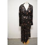 A late 1930s/1940s glossy black rayon house coat, having bright floral sprigs, pocket and dramatic