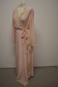 A pale pink Art Deco 1930s full length dressing gown, having deep lace trim, bell shaped sleeves and