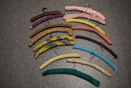 A collection of vintage fabric and crochet covered coat hangers.