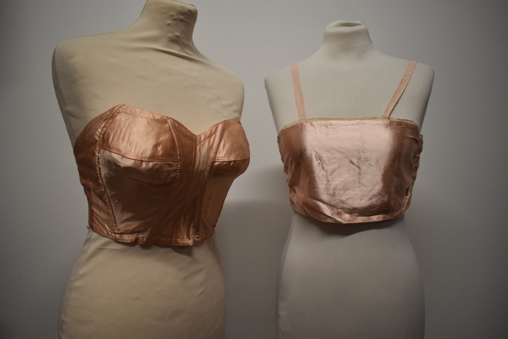 A 1940s strapless pink satin finish bra and a 1920s bralette with shirred back.