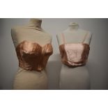 A 1940s strapless pink satin finish bra and a 1920s bralette with shirred back.
