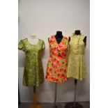 Three vintage 1960s brightly patterned mini dresses.