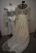 A 1970s nylon wedding dress with long train, full length sleeves and high neckline and a 1980s