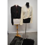 An early 20th century black blouse with fancy red buttons and embroidery to collar, a 1960s cream St