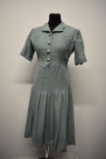 A mint green wool 1940s day dress, having scalloped collar, buttons and detailed pockets to front,