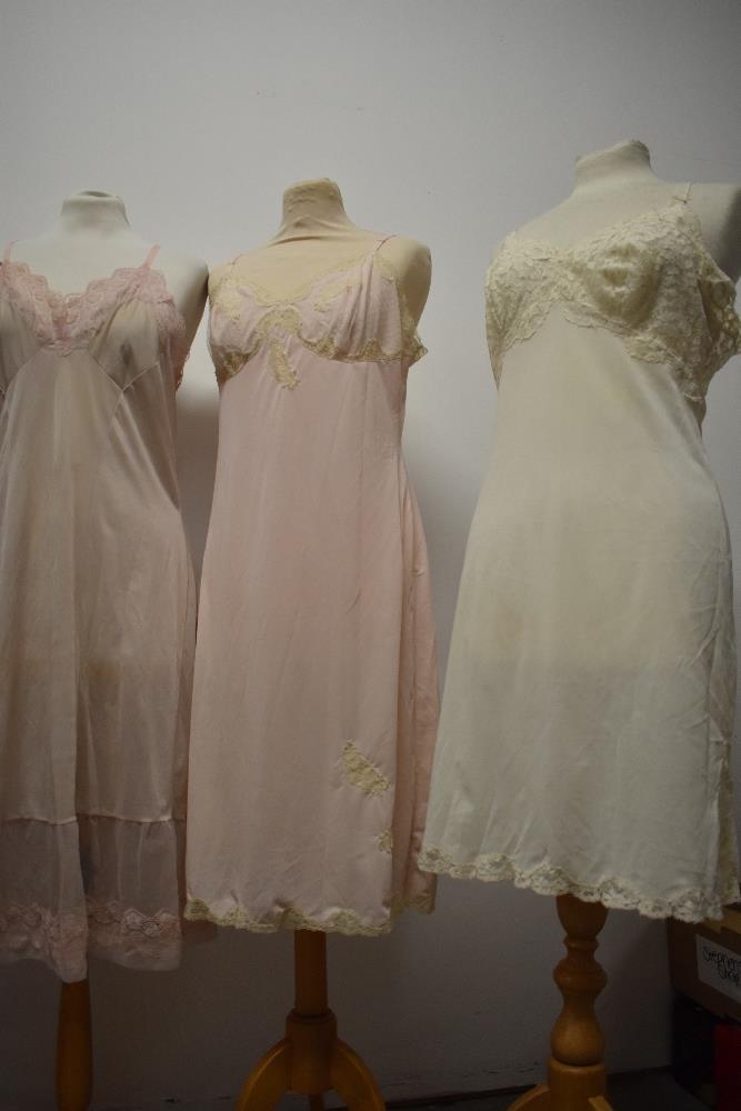 Five 1950s and 1960s sheer and semi sheer nylon slips, all having lace, medium to large sizes. - Image 12 of 12