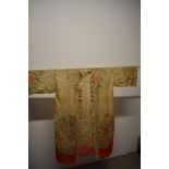 An early 20th century cream silk kimono dressing gown, having traditional scenes of buildings,