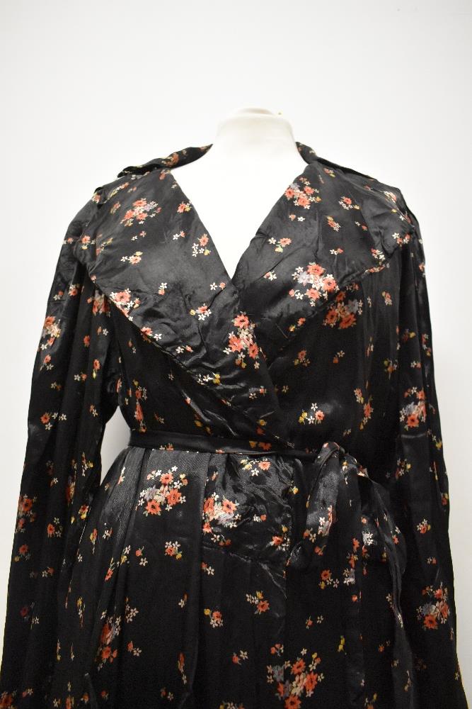 A late 1930s/1940s glossy black rayon house coat, having bright floral sprigs, pocket and dramatic - Image 4 of 7