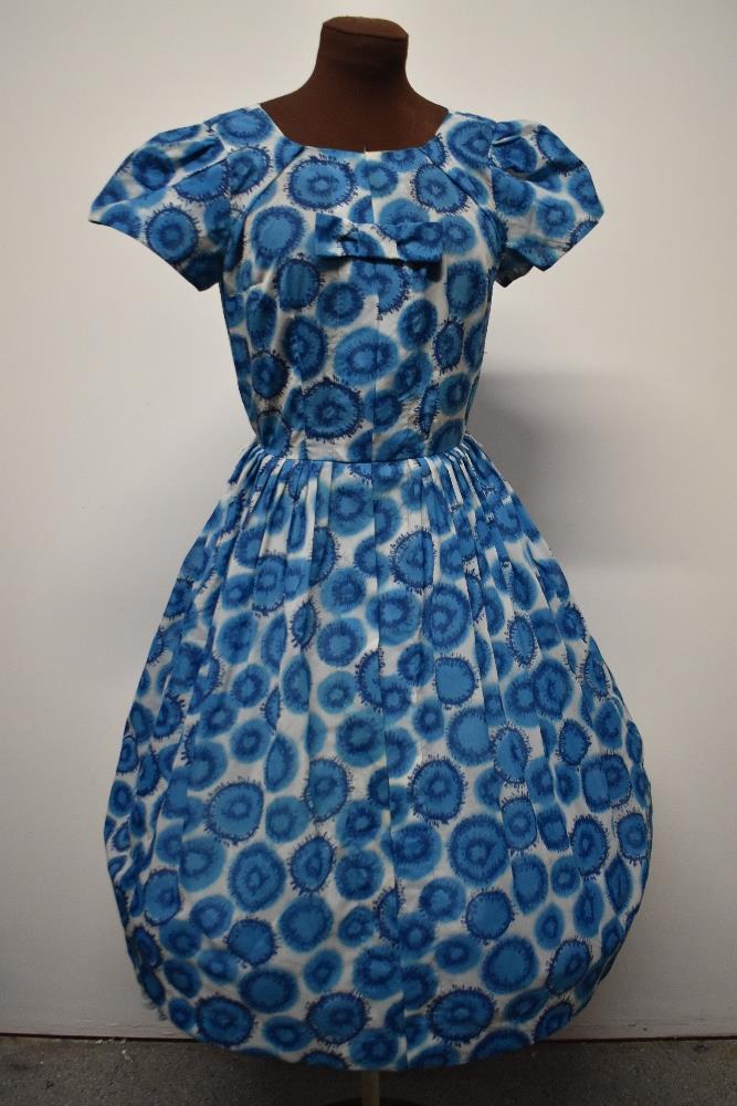 A blue 1950s day dress, having side metal zip, fairly full pleated skirt and bow detail to