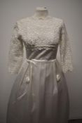 An early 1960s wedding dress having scoop neckline, floral detailing to upper bodice and three