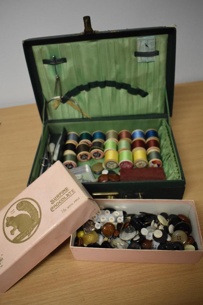 A vintage green case, containing an assortment of thread, buttons, needles, crotchet hooks etc.