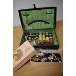 A vintage green case, containing an assortment of thread, buttons, needles, crotchet hooks etc.