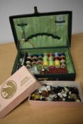 A vintage green case, containing an assortment of thread, buttons, needles, crotchet hooks etc.
