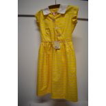 A 1950s dead stock children's yellow cotton day dress with original tag, having striped pattern in