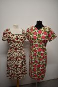 Two 1950s/60s dresses, having bright rose patterns.