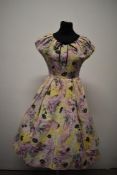 A 1950s cotton day dress, having abstract painterly pattern in pink, yellow, pale blue and black,