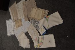 An assortment of vintage and antique table linen, including colourful embroidered table cloths