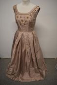 A 1950s ball gown of taupe shot satin or similar, having extensive beading, metal thread accents and