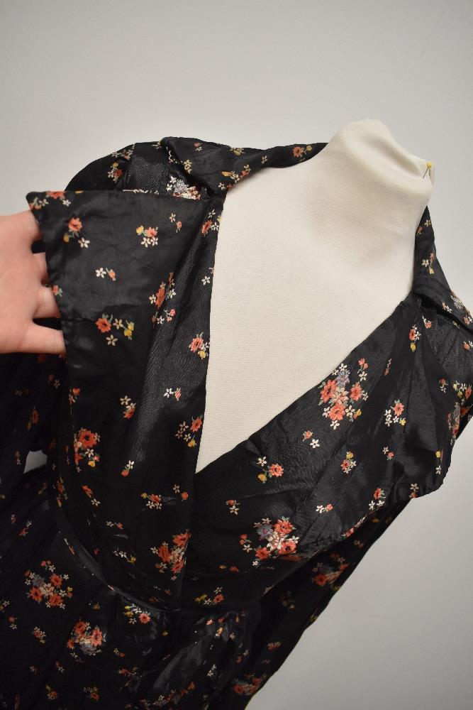 A late 1930s/1940s glossy black rayon house coat, having bright floral sprigs, pocket and dramatic - Image 2 of 7