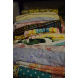 A box full of vintage and retro bedding, towels, a table cloth, a travel rug and similar.