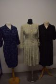 Three 1950s day dresses, comprising; navy blue patterned dress, black textured crepe dress and