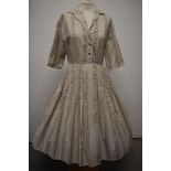 A 1950s cotton shirt waister with full pleated skirt, having taupe pattern on cream ground,