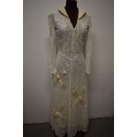 A 1930s lace wedding dress, having cream satin quilted collar, and quilted appliqué crosses to