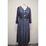 A 1950s slate blue dress with white fleck running throughout, shawl collar, buttons to front,